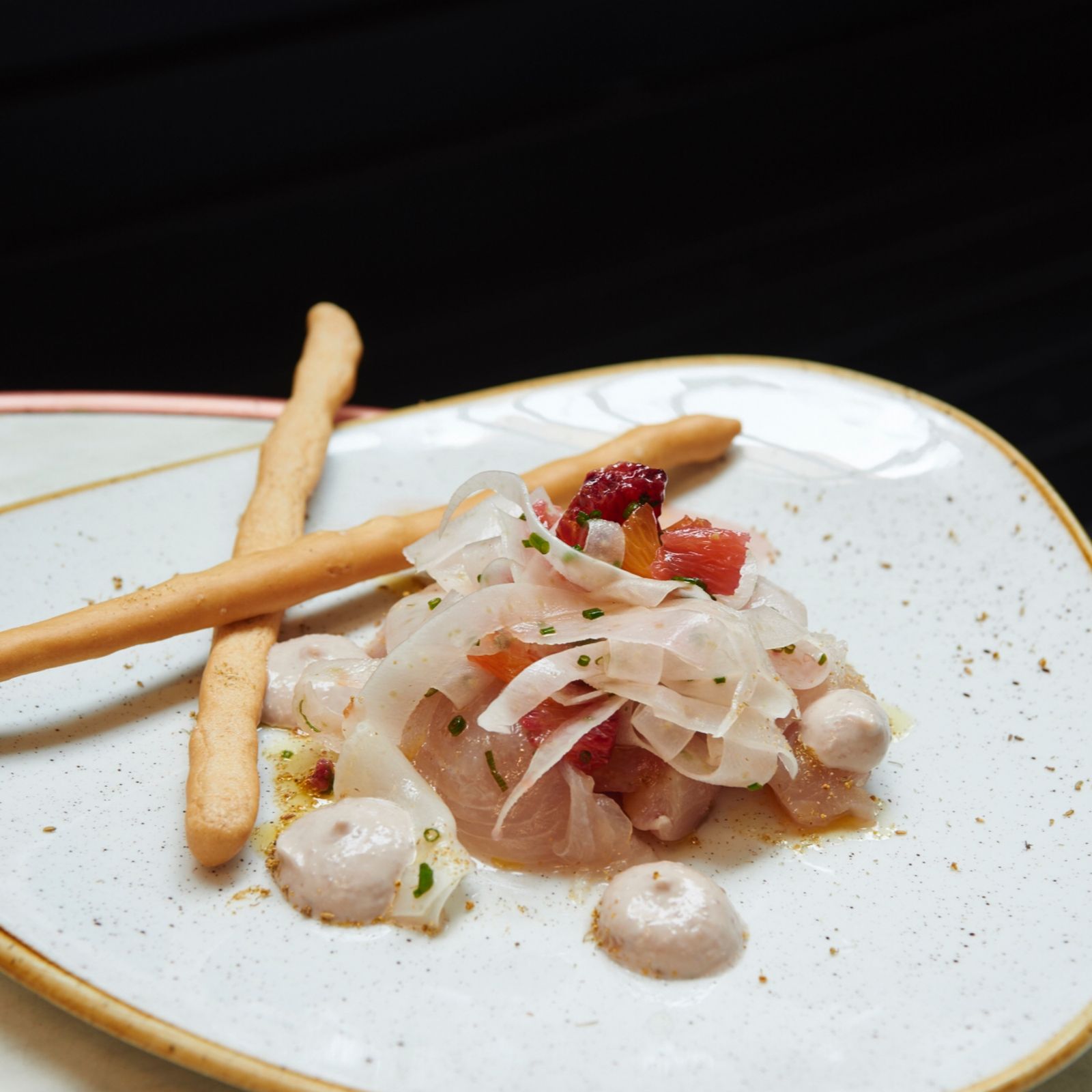 From above of appetizing dish with cellophane noodles garnished with sauce and berries served on plate with crunchy bread sticks